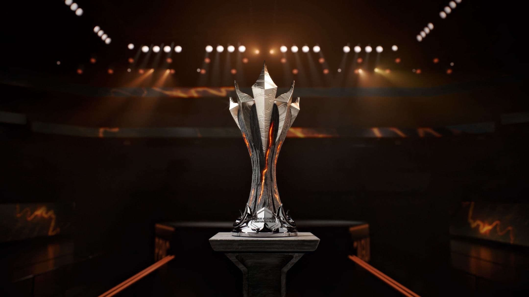 Silver LCP Riot trophy with sharp, angular points sits on a pedestal under dramatic stage lights in a dark arena, with spotlights illuminating it from above.