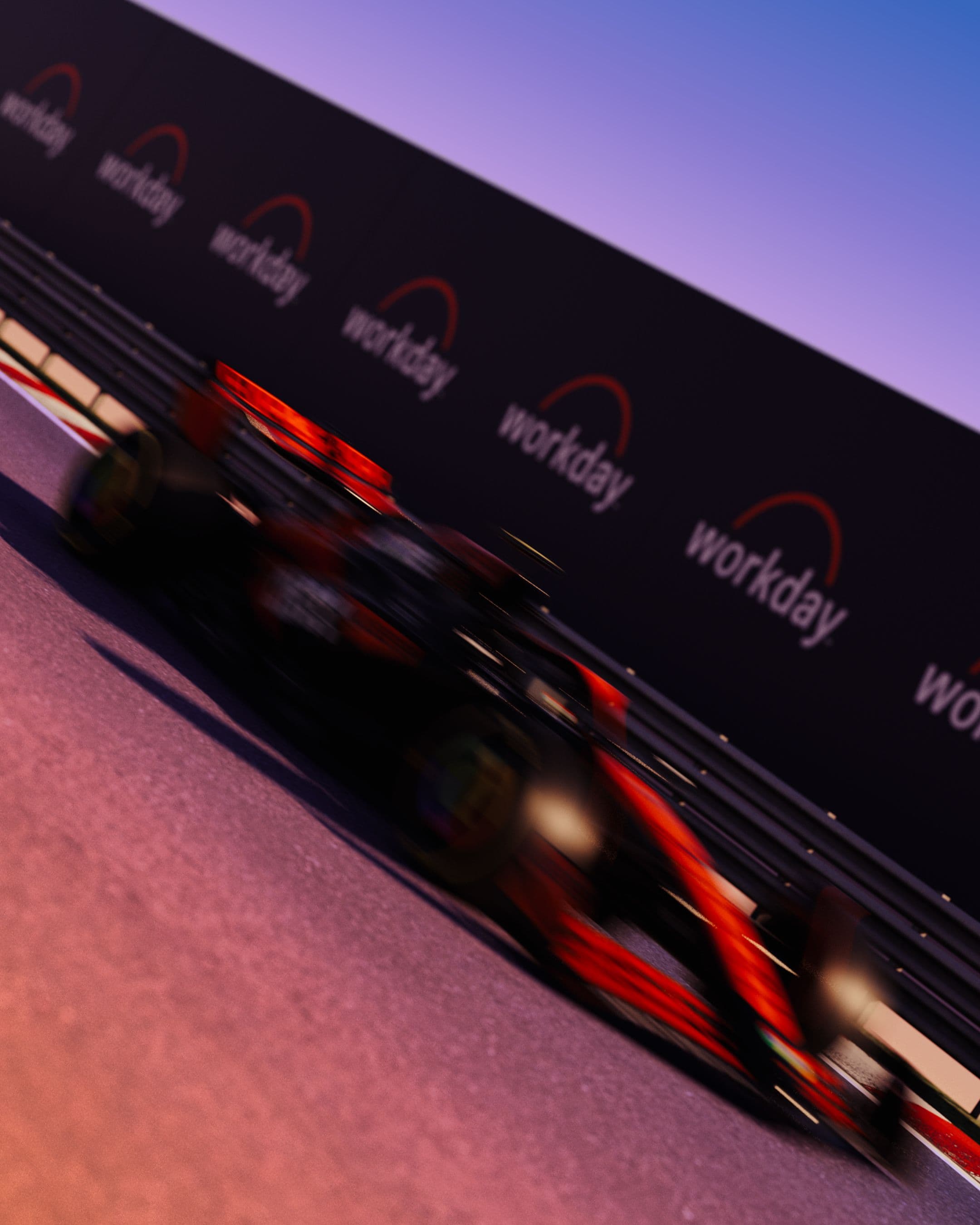 A red Formula 1 car speeds past a black barrier with repeated workday logos, motion blur showing its fast movement.