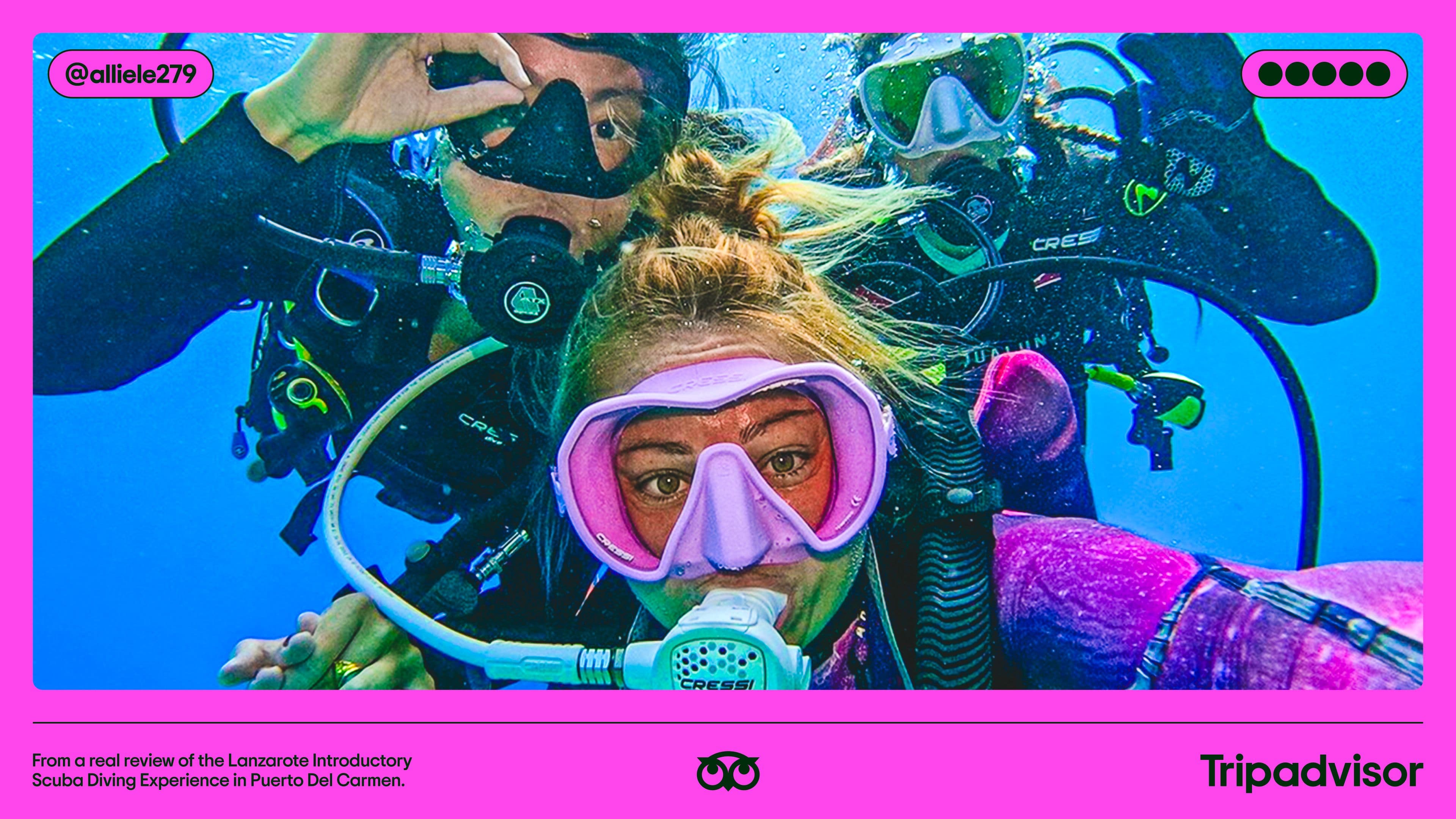 Three people in scuba gear take an underwater selfie, surrounded by blue water. They wear masks and wetsuits, with bubbles visible. The image has a bright pink border featuring social media and Tripadvisor branding.