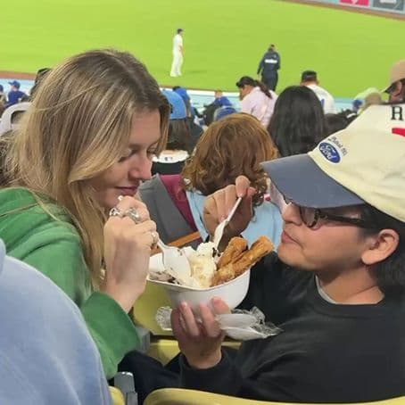 Koto New York team members sharing churro-topped ice cream at a baseball stadium during a game.