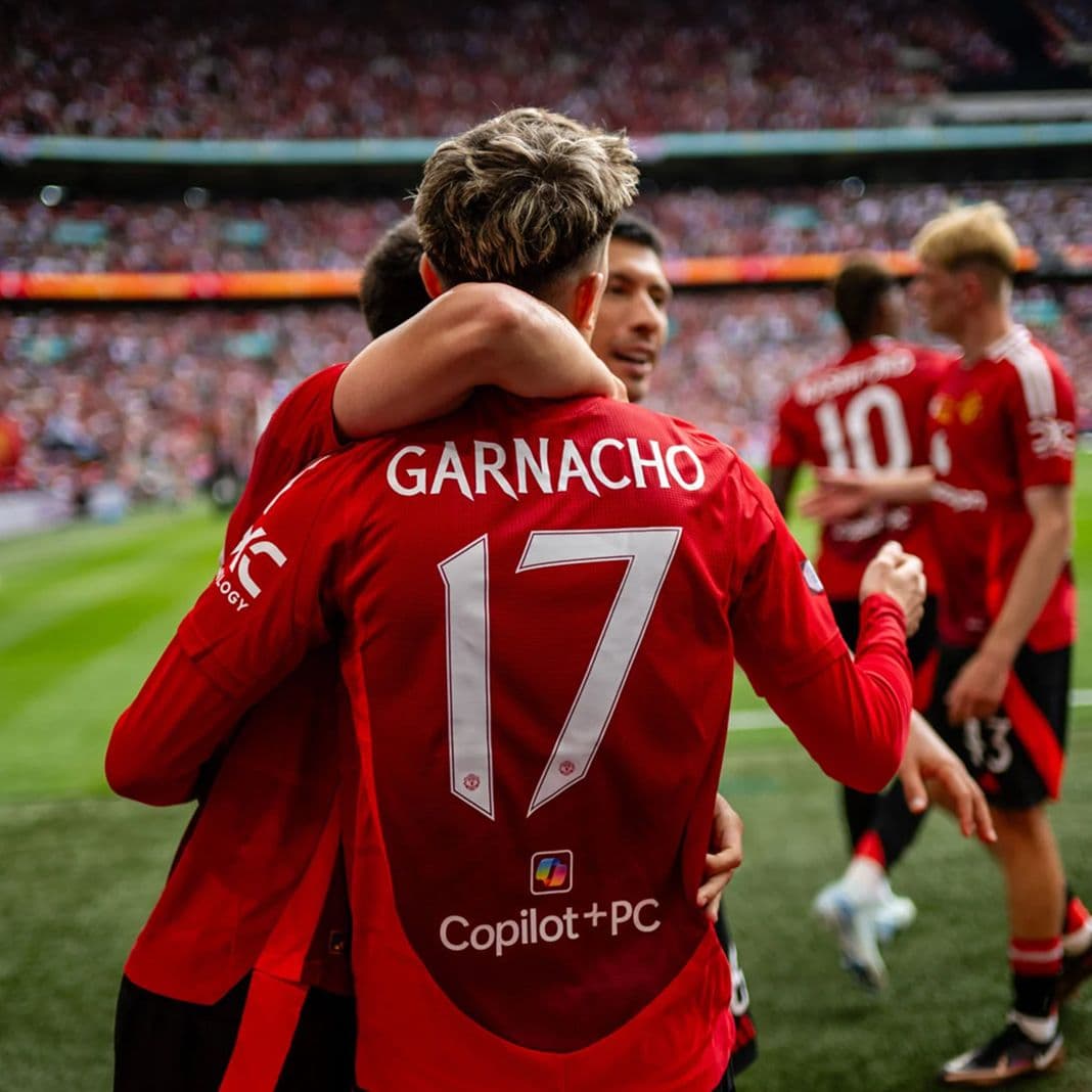 Manchester United player Garnacho (#17) celebrating with teammates, crowd behind, Copilot and PC logos on his jersey back.