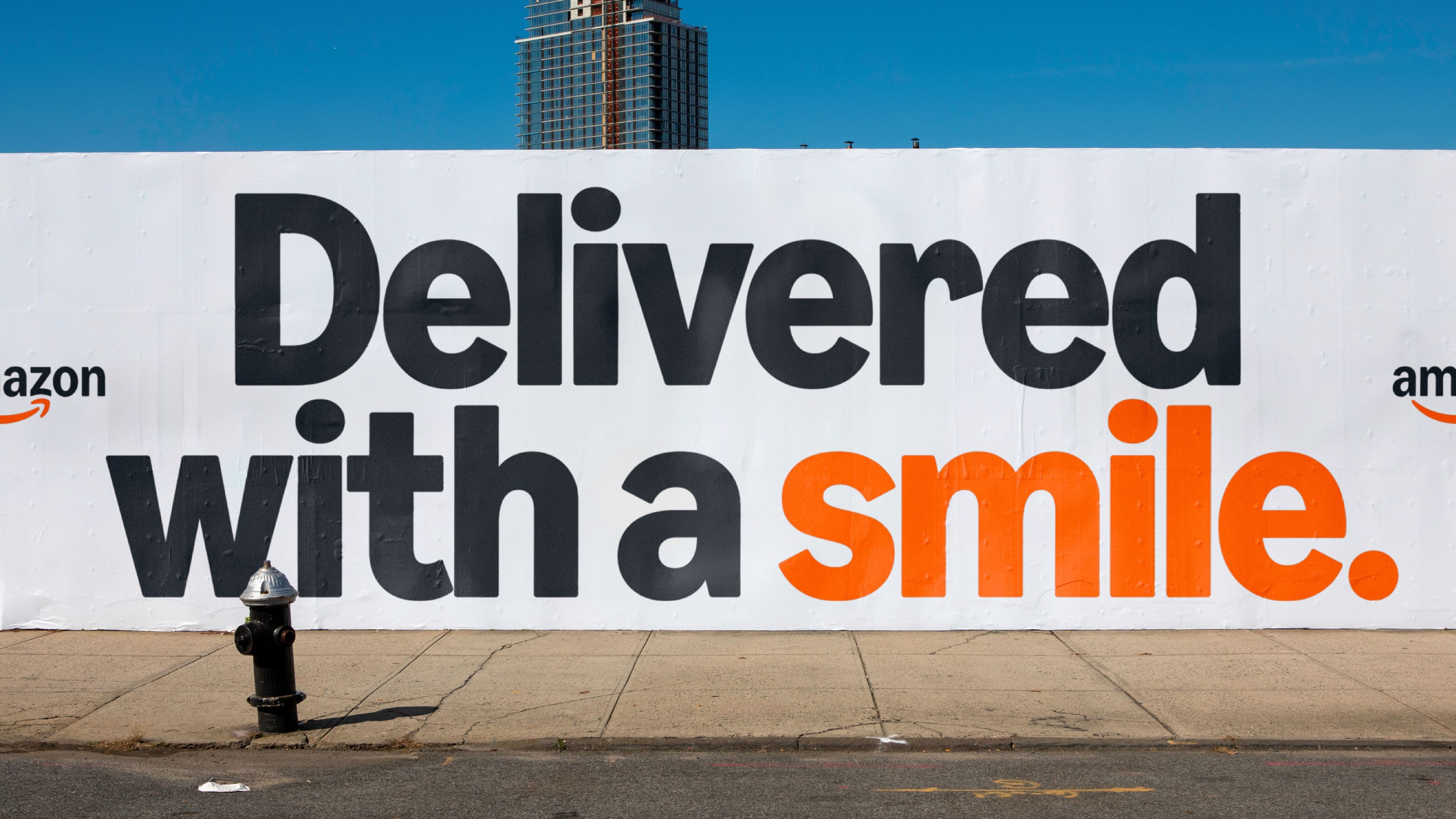Wall with Amazon marketing reading ‘Delivered with a smile.’