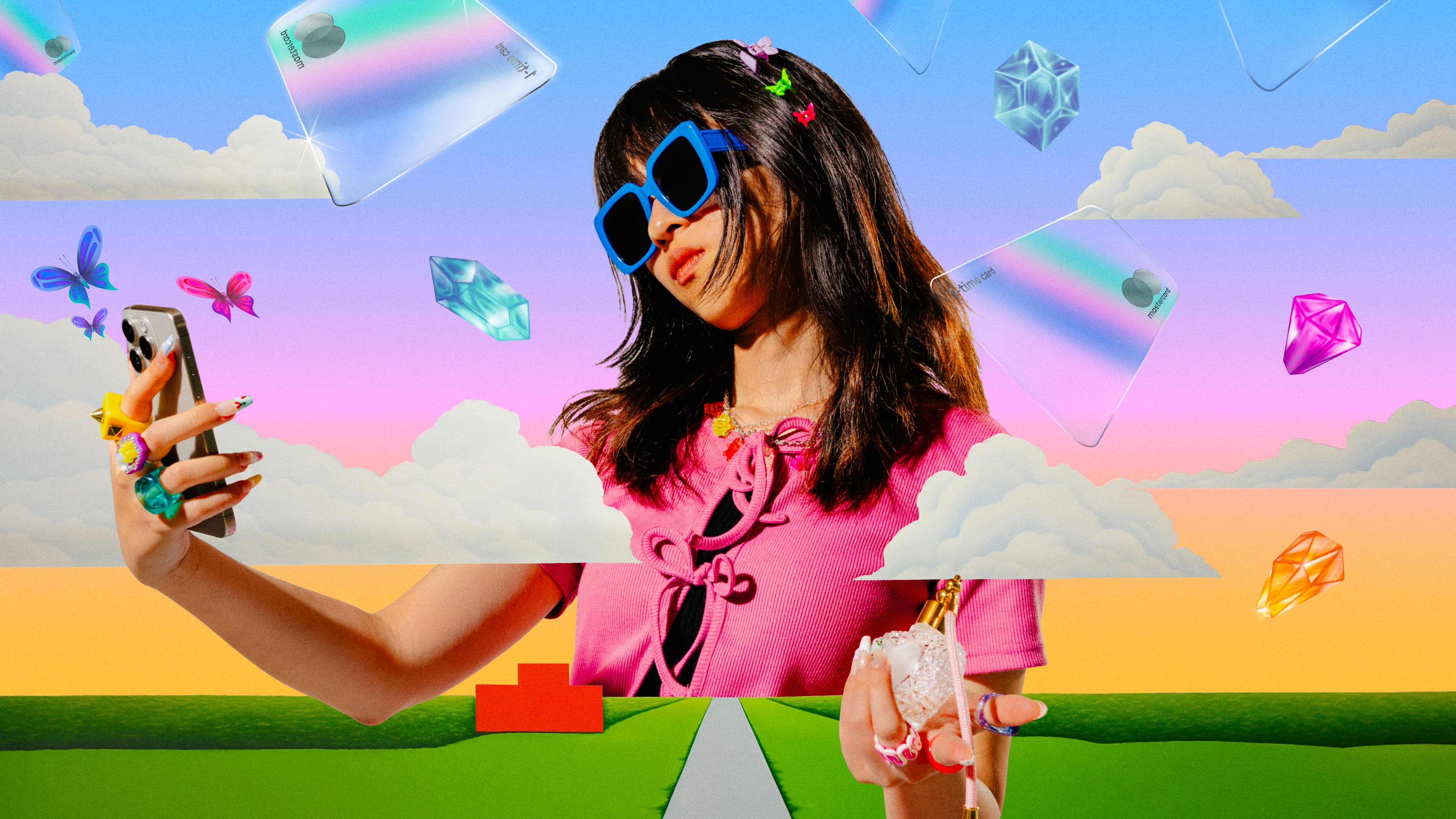 A stylish woman in a pink top and large blue sunglasses takes a selfie against a surreal, colorful background with floating credit cards, gems, butterflies, and clouds, giving the scene a playful, whimsical feel.