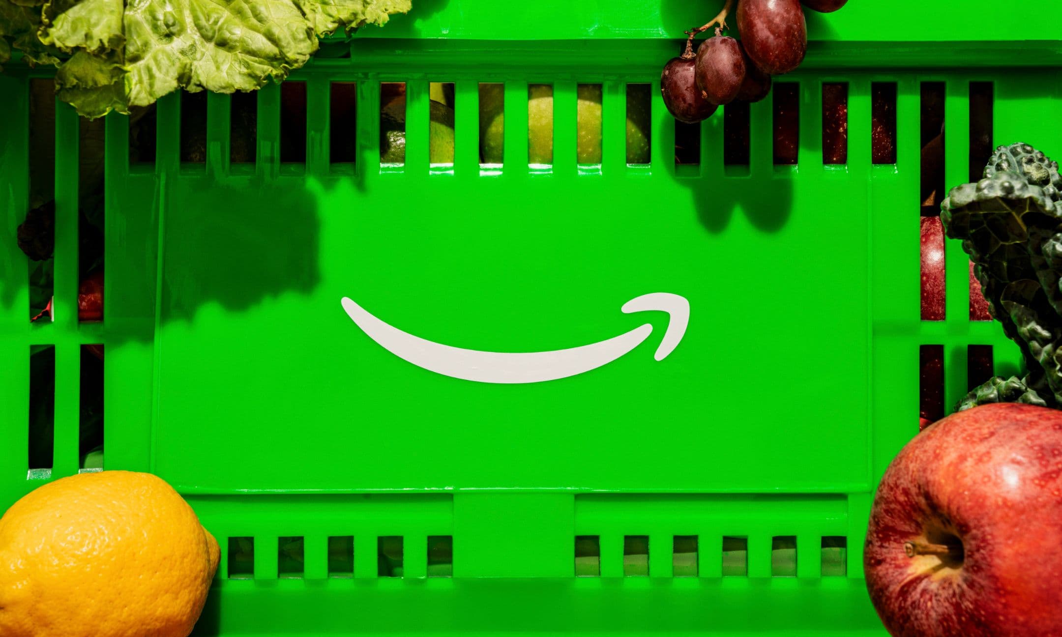 Bright green basket with the Amazon smile logo, filled with fresh produce