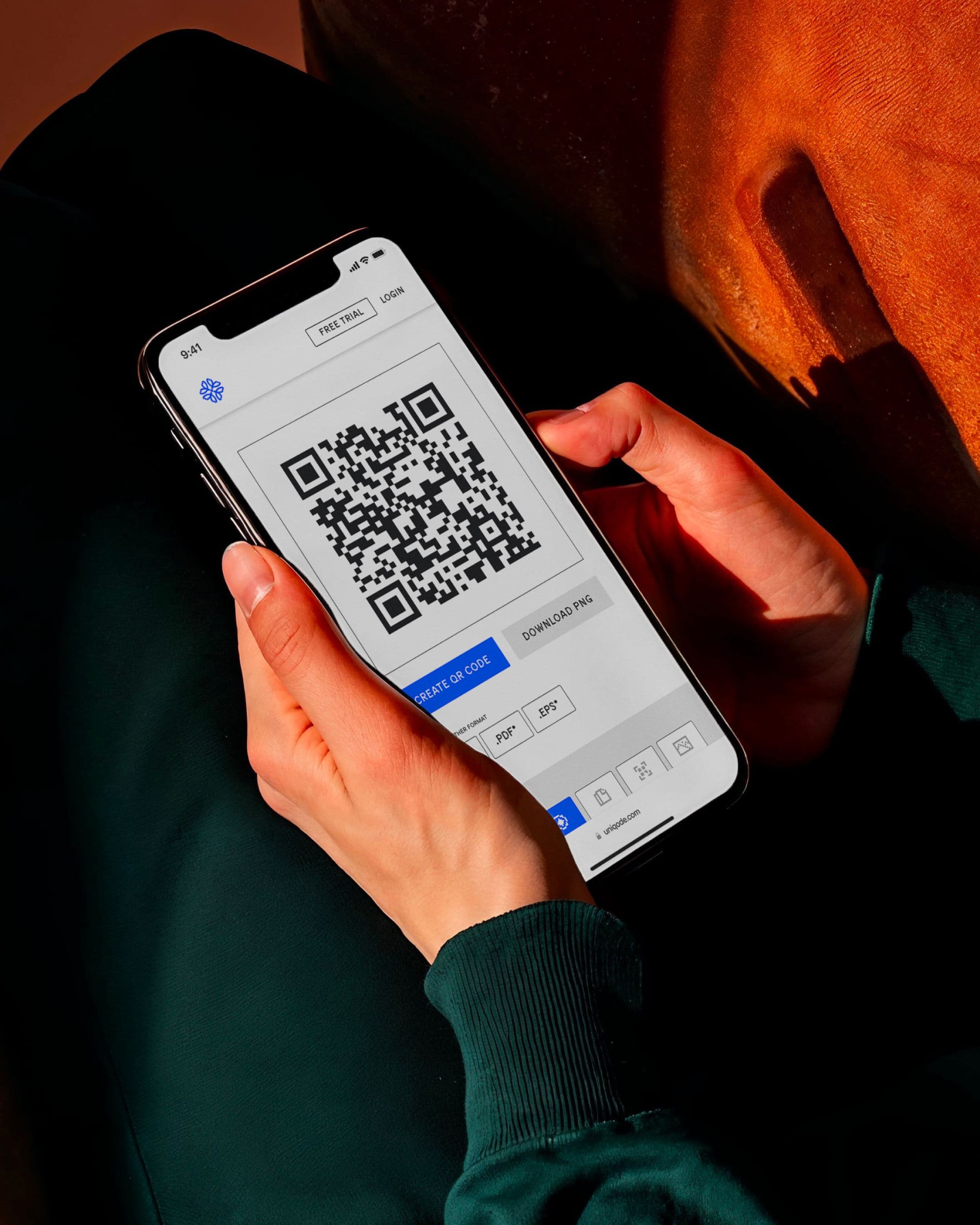 A person holding a smartphone displaying a QR code in the Uniqode app.