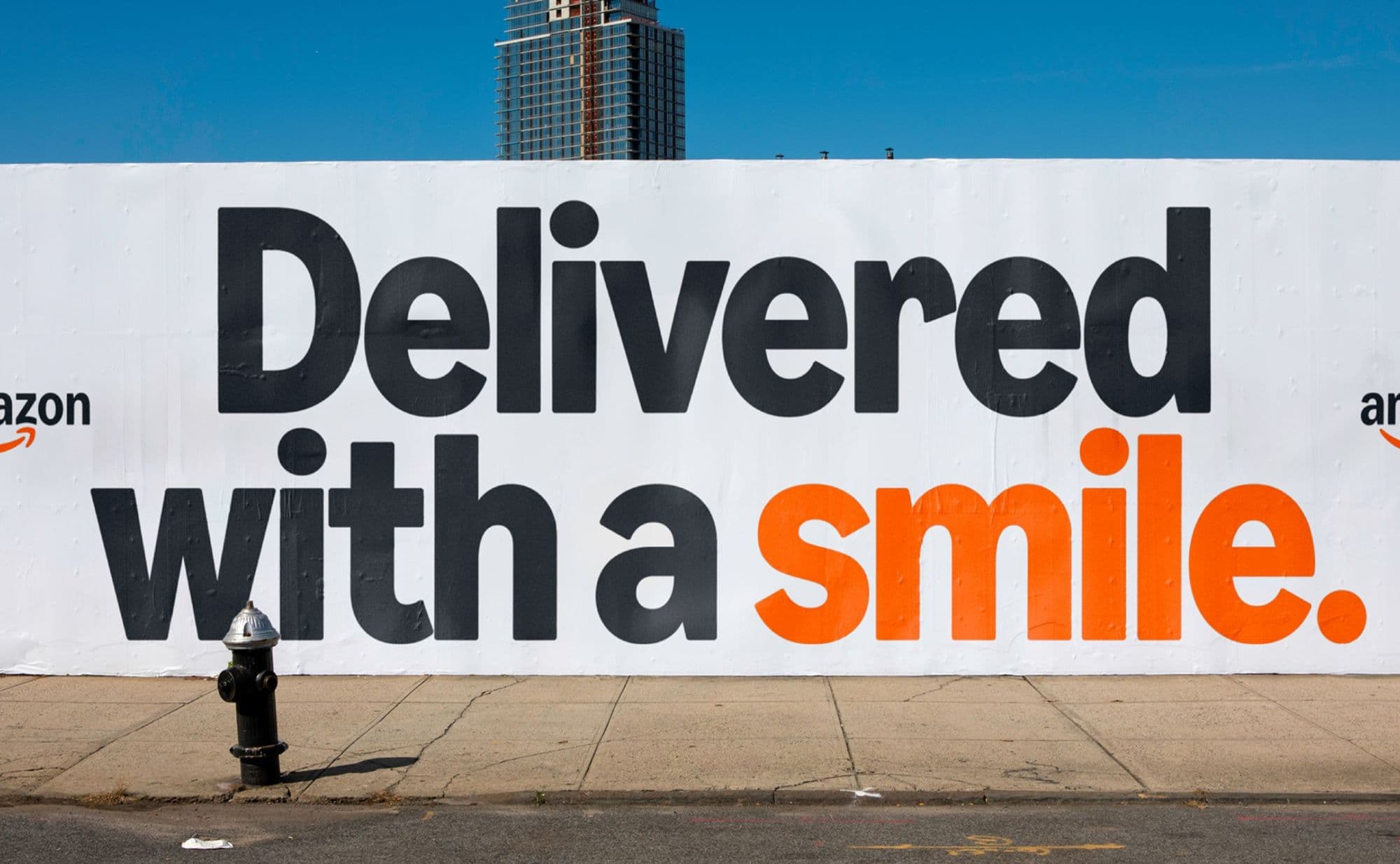 Wall with Amazon marketing reading ‘Delivered with a smile.